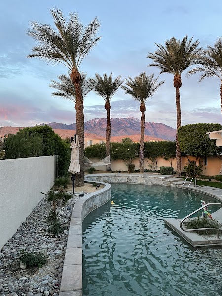 Elegant residential pool and spa surrounded by desert landscaping with mountain backdrop in Palm Desert, California